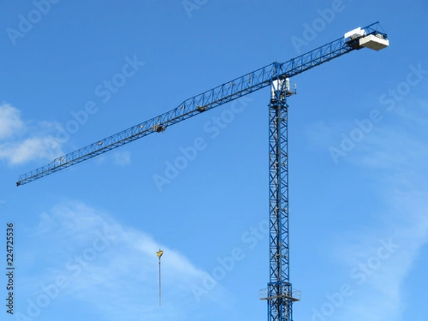 Obraz Construction crane against blue sky with white clouds