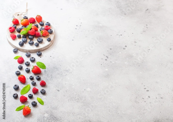 Fototapeta Fresh raw organic berries on round vintage board background. Space for text. Top view. Strawberry, Raspberry, Blueberry and Mint leaf