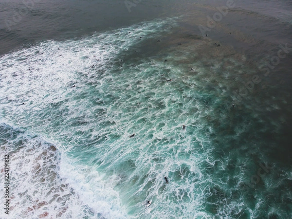 Fototapeta View of Praia do Guincho, Guincho beach, a popular Atlantic Ocean beach on Portugal's Estoril coast, municipality of Cascais, with surfers surfing on the waves, shot from drone