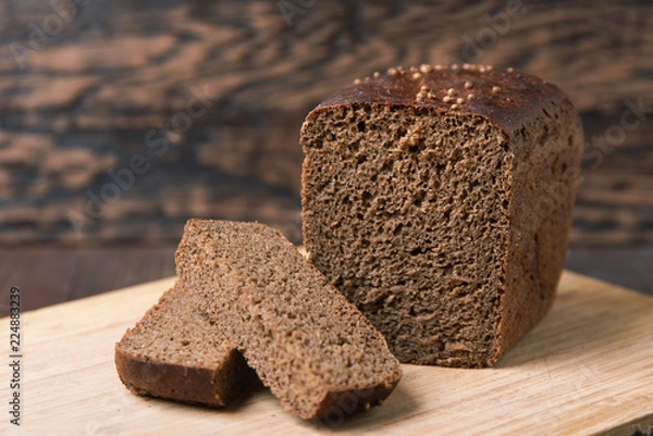 Obraz Black rye bread with coriander on a wooden background