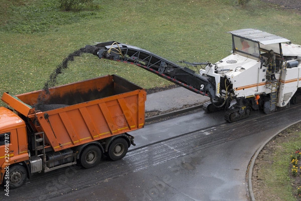 Obraz Road milling machine removes old asphalt and loads milled asphalt into the dump truck. Road repair process