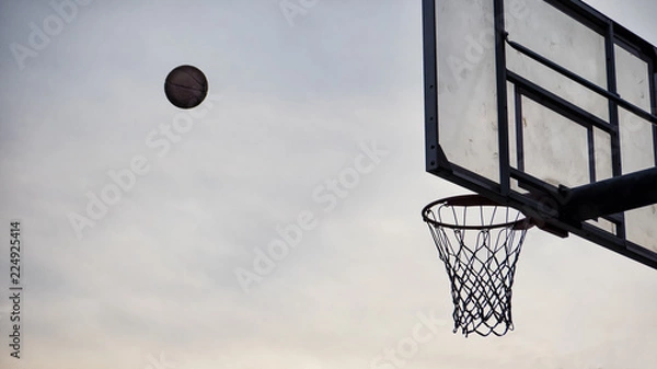 Fototapeta Baskaetball flying into the hoop