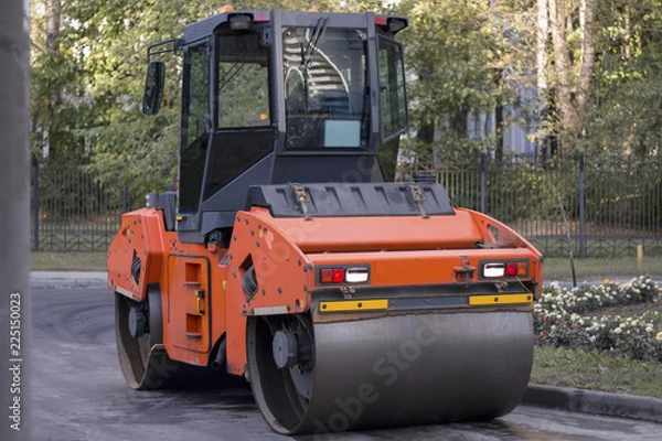 Obraz Road construction working. Heavy Vibration roller compactor flatten out new asphalt. Road renewal process.