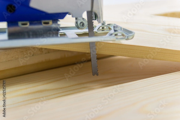Fototapeta Close-up electric sawing jigsaw with wood the start process of cutting the board