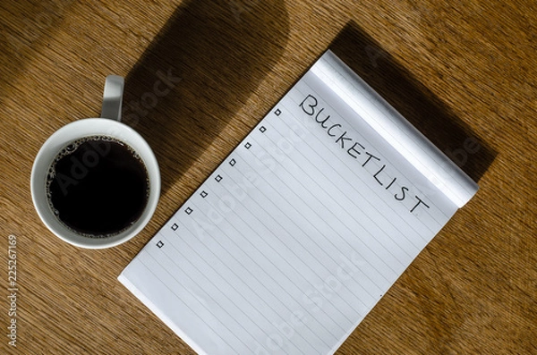Fototapeta Coffee and a note block with bucket list items