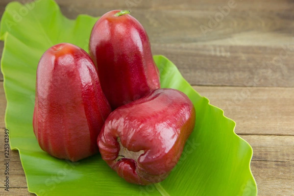Obraz red rose apple on green leaf, selective focus