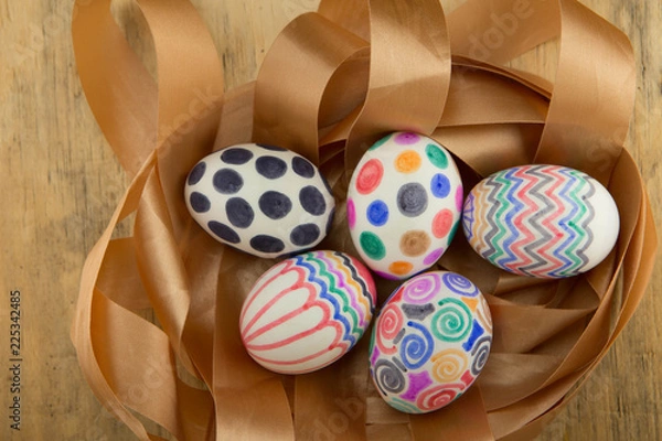 Obraz colorful easter eggs on gold ribbon