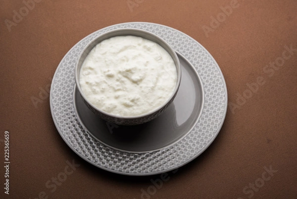 Fototapeta Plain curd or yogurt or Dahi in Hindi, served in a bowl over moody background. Selective focus