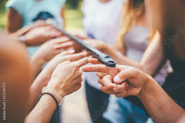 Fototapeta teambuilding exercises with stick and hands unity