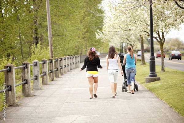Fototapeta Women walking on a boardwalk.