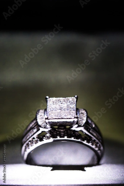 Fototapeta A diamond engagement ring in a box with glint/reflection. Shimmering princess-cut diamonds.