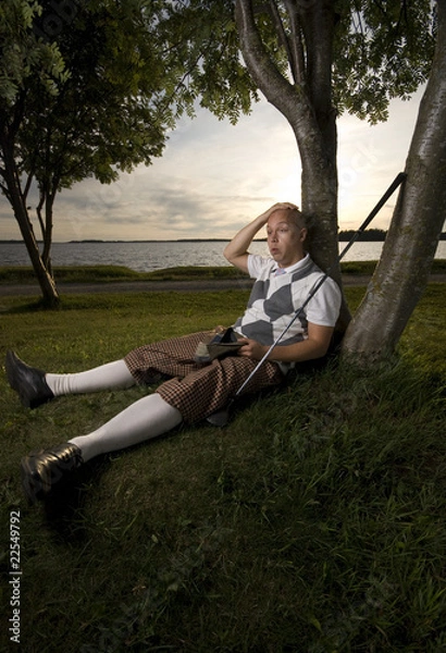 Obraz Exhausted golfer resting under a tree.
