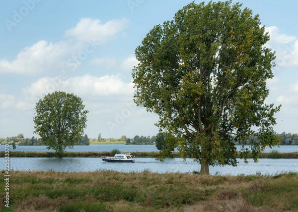 Obraz River landscape with small cruiser