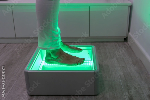 Fototapeta Orthopedics, foot podoscope test. Female feet during a podoscopic examination in an orthopedic surgery