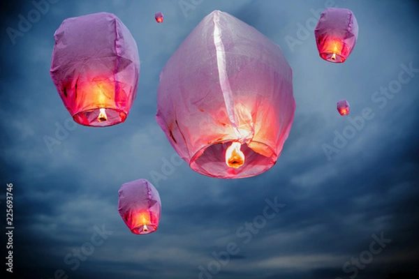 Fototapeta balloon fire Sky lanterns flying lanterns, hot-air balloons Lantern flies up highly in the sky. Floating lanterns at dawn during