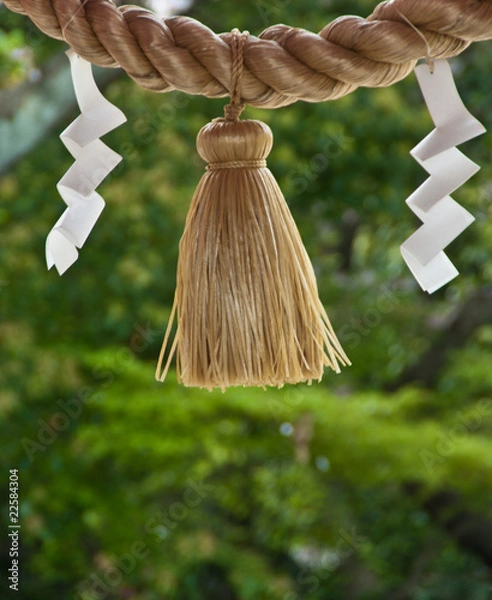 Fototapeta A rope and folded paper outside a shrine in Japan
