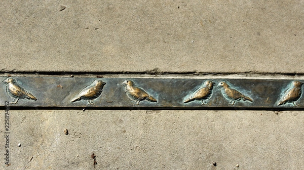 Fototapeta Серая стена со стальной полосой украшенной орнаментом из птиц
