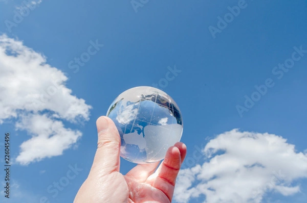 Obraz 青空を背景にガラスの地球を掲げる手