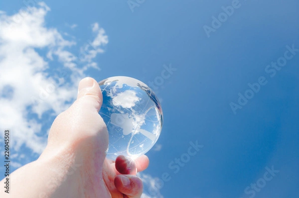 Obraz 青空を背景にガラスの地球を掲げる手