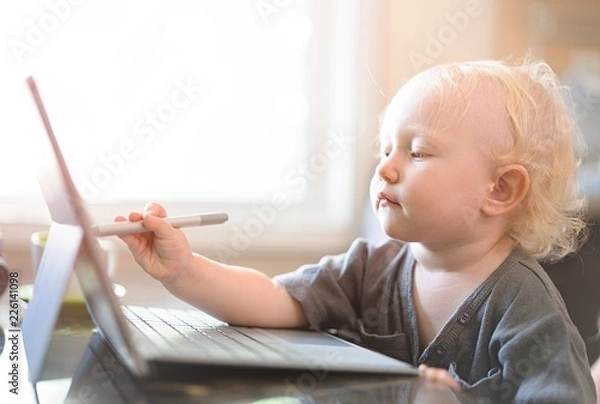 Obraz Little baby learning to use laptop computer .