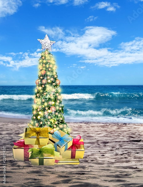 Obraz Decorated Christmas tree on sandy beach over sea with suny sky