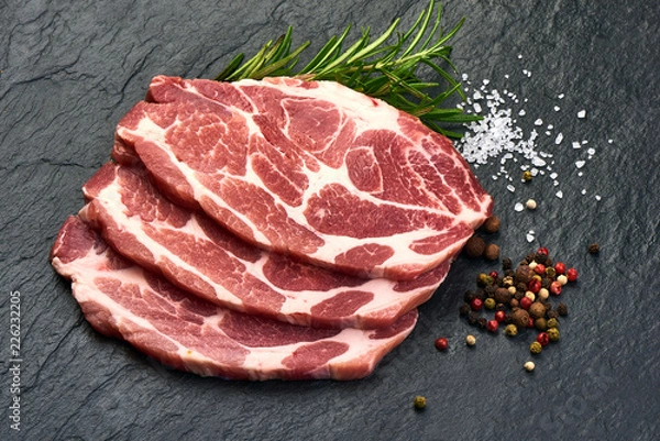 Fototapeta Meat, pork, slices pork loin with herbs on a slate shale plate.