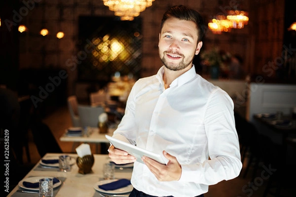 Fototapeta Smiling man with tablet in restaurant