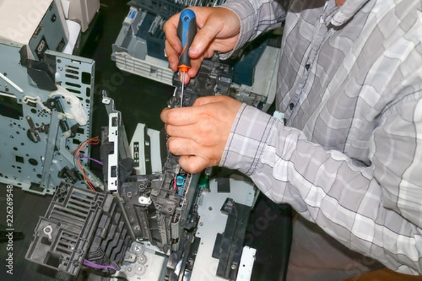 Obraz Repair of the laser copier-printer in the service center. Replacing worn gears.