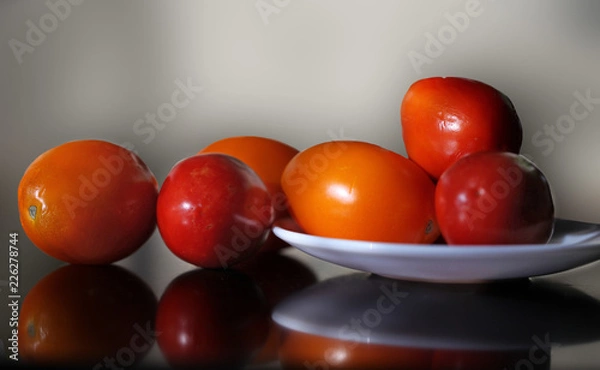 Fototapeta Ripe yellow and red tomatoes lying on the table