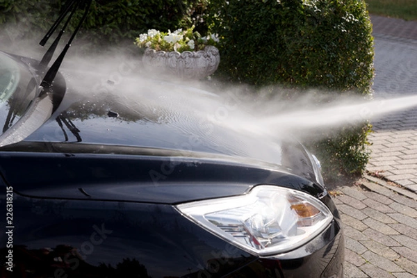 Fototapeta Cleaning the black car, car care concept - Car washing under high pressure water