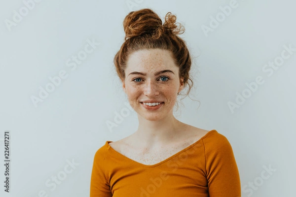 Obraz Woman portrait. Style. Beautiful blue eyed girl with freckles is looking at camera and smiling, on a white background