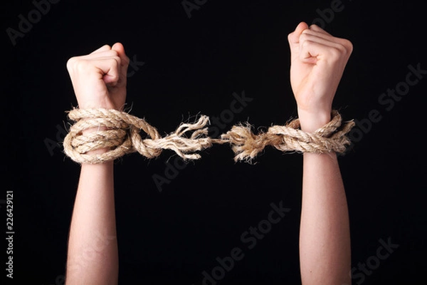 Obraz Unrecognizable person getting free is raising arms showing a frayed rope