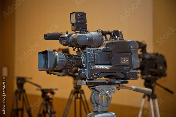 Fototapeta Professional video camera set on a tripod with excellent clipping path . Professional production video camera. video camera in business conference room recording participants