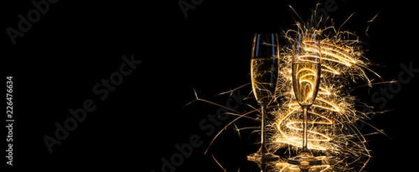 Obraz Glasses with champagne in the golden light of Bengal lights