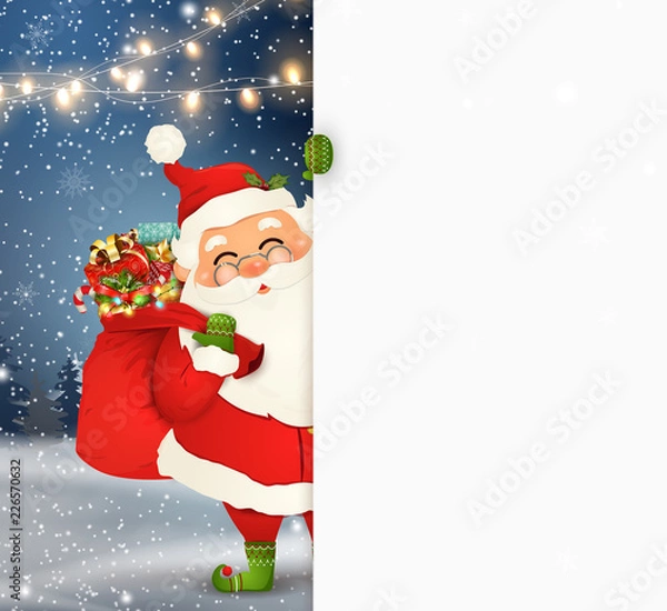 Fototapeta Happy Santa Claus standing behind a blank sign, showing on big blank sign. Cartoon Santa Claus character with gift bag full of gift boxes, white copy space. Holiday winter landscape with firs, snow