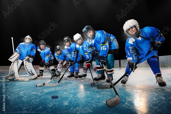 Obraz Dzieci na łyżwach z krążkiem podczas treningu hokeja