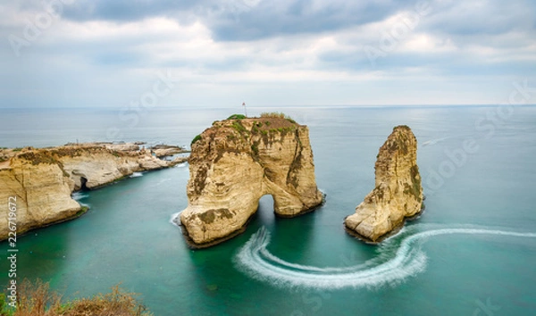 Obraz Rouche rocks in Beirut, Lebanon near sea and during sunset. Cloudy day in Beirut Lebanon at Pigeon Rocks in Mediterranean sea.