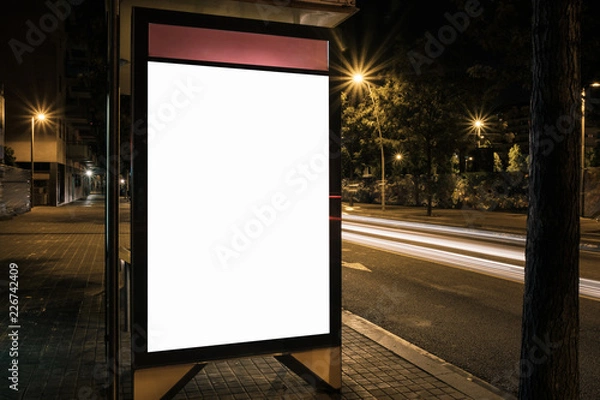 Fototapeta Light box display with white empty space for advertisement at bus station. Horizontal mock-up design concept with car light trails at night.