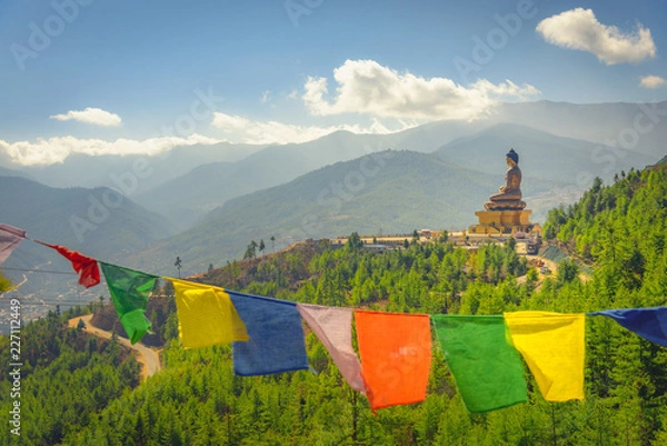 Obraz Paro Buddha with prayer flags in foreground and the valley in the background