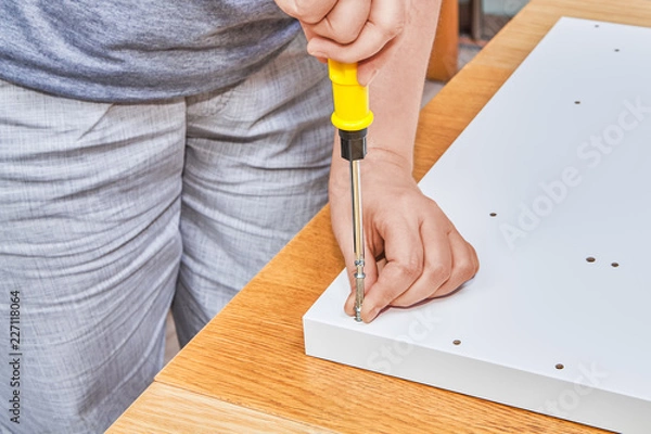 Obraz Installer screws fastening furniture screw into white chipboard.