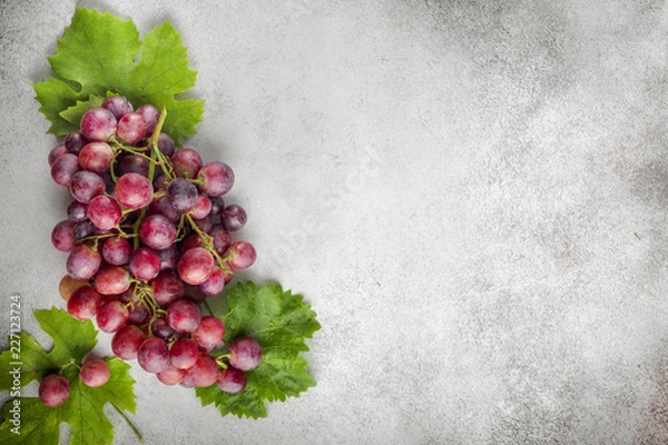Fototapeta Red grapes over stone table. Top view with copy space