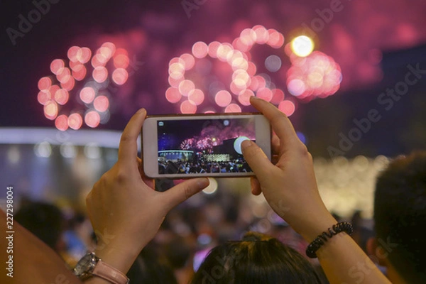 Obraz Holiday, colorful sky, fireworks shoots on smartphone