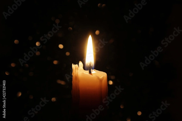 Fototapeta Candles Burning at Night. White Candles Burning in the Dark with focus on single candle in foreground. 