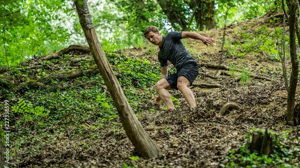 Obraz the guy is running down a steep hill while participating in an ocr race