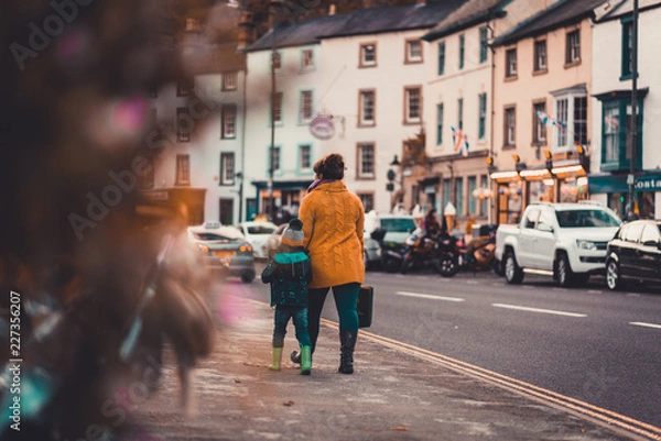 Fototapeta A mother and her son walk down Matlock Bath toward the Matlock Bath Illuminations in October, 2018