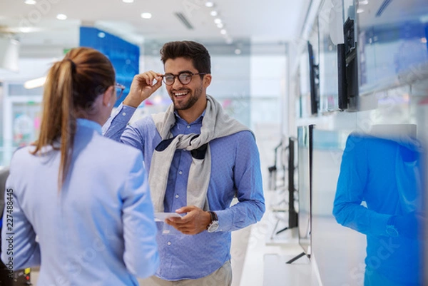 Fototapeta Wielorasowa para w sklepie technicznym poszukująca nowego telewizora do swojego domu.