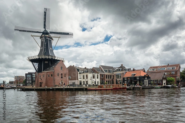 Fototapeta The eight-sided smock mill De Adriaan on the river De Spaarne in Haarlem