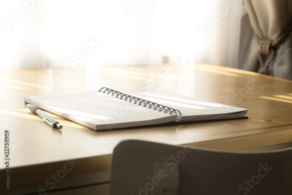 Fototapeta Notebook and pen on a table.