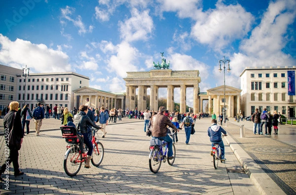 Obraz Ludzie na rowerze w pobliżu Bramy Brandenburskiej w Berlinie, Niemcy