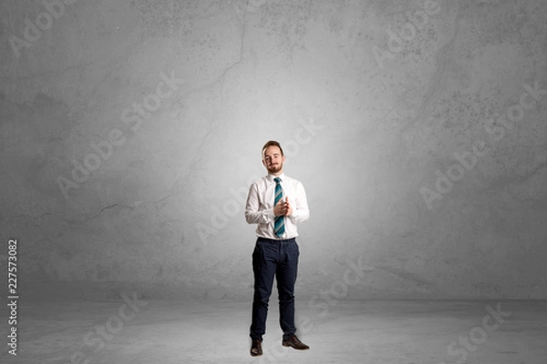 Fototapeta Alone handsome businessman standing in a dark empty room